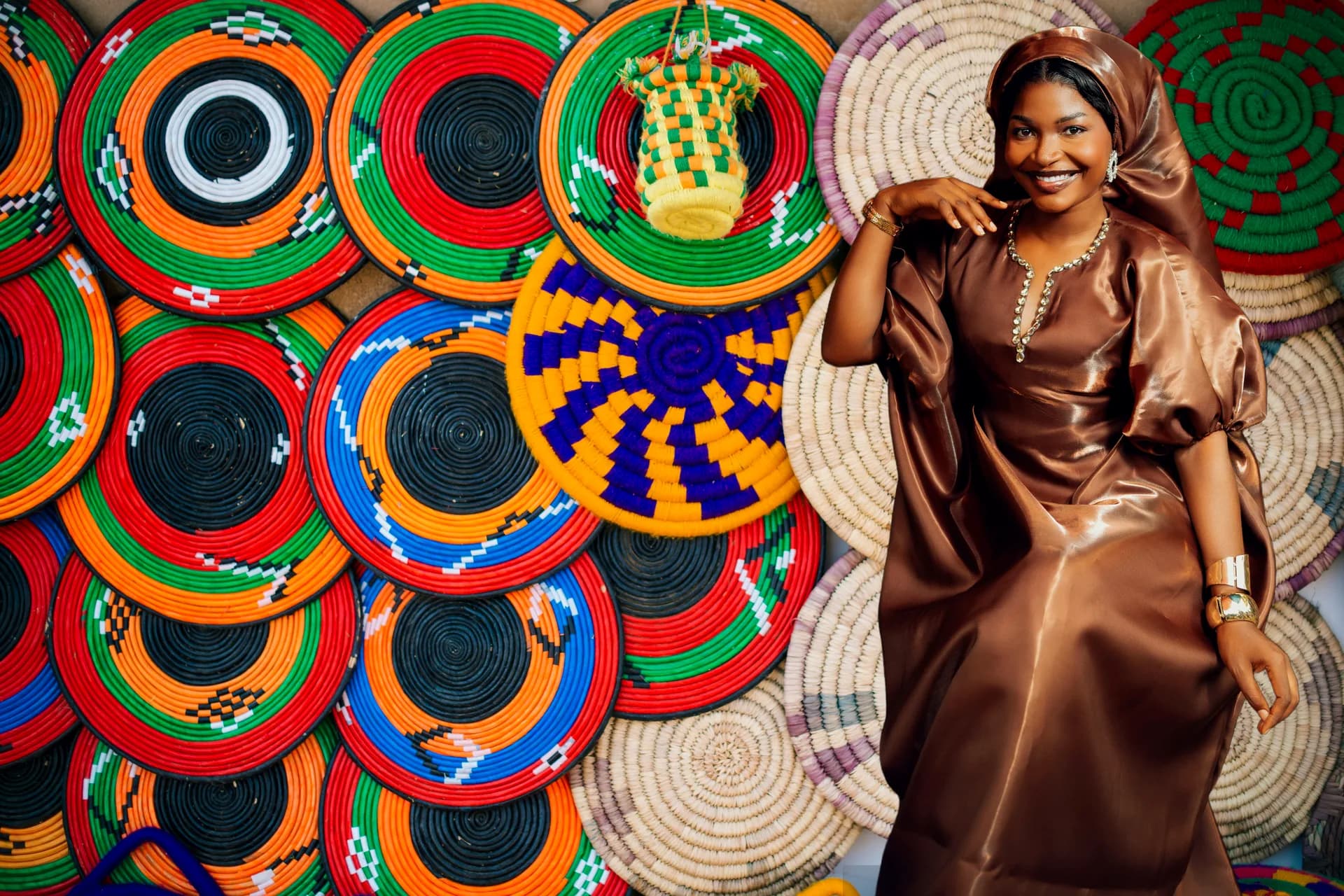 A smiling shop owner standing in front of her colourful handmade craft baskets