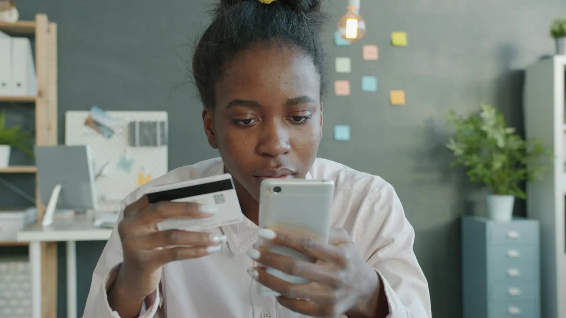 Woman shopping online with her phone and bank card